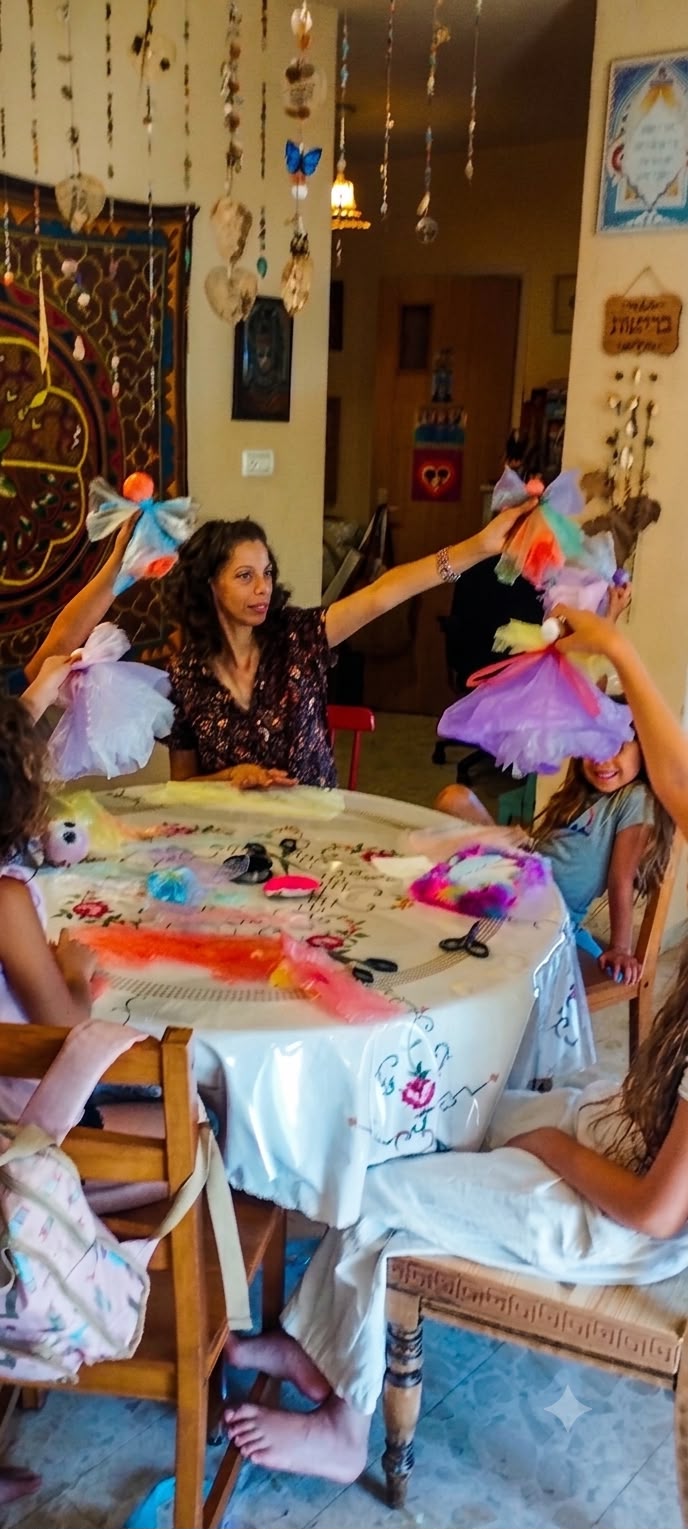יצירה משותפת סביב השולחן בסלון, עם כנפי פיות מטול ובדים