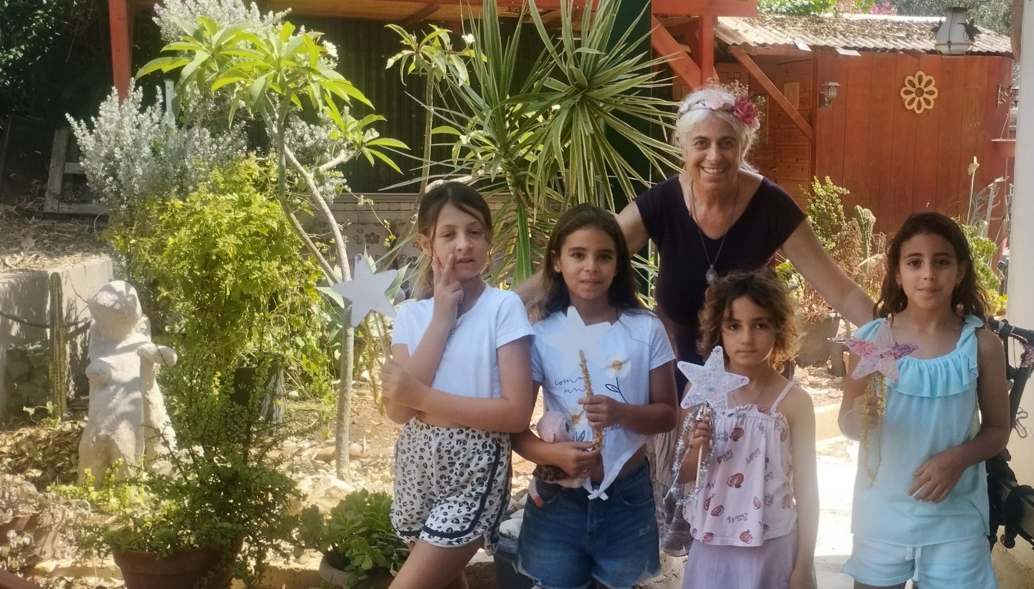 הפיות של הקייטנה עם שרביטי כוכבים שיצרו, בחצר בית הקסם